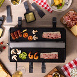 Raclette grill Venti from above, loaded with food and dishes with cheese slices.