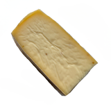 wedge of raclette cheese with fenugreek seeds