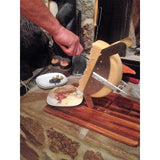 Scraping melted raclette from cheese wheel
